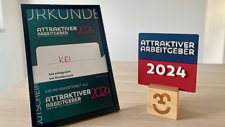 Foto von der Urkunde und der Auszeichnung als "Attraktiver Arbeitgeber" 2024